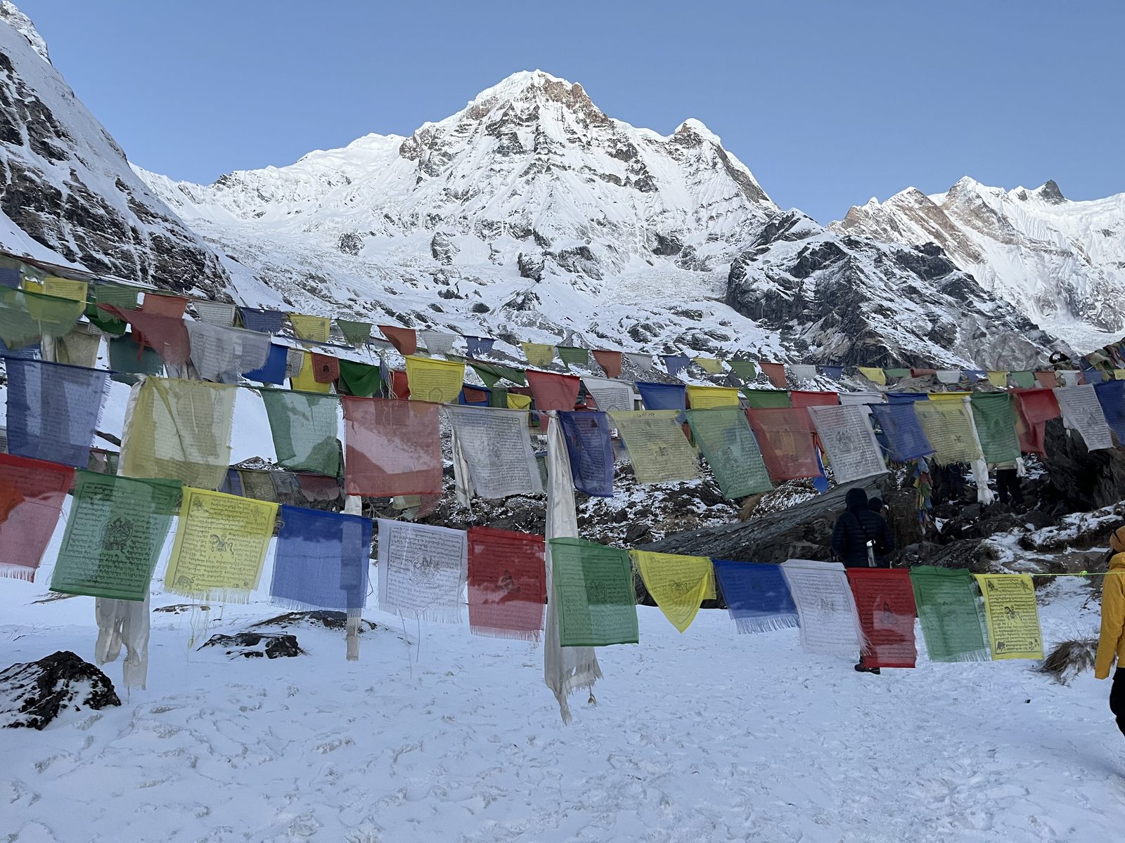 Prayer flags in the snow with the Annapurna Sanctuary peaks behind