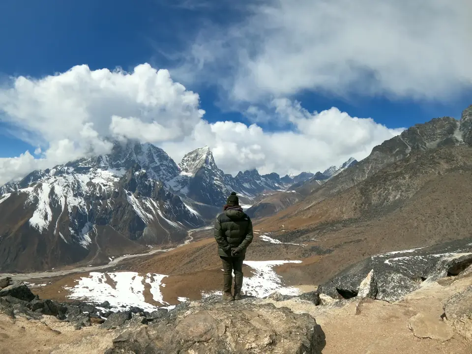 A trekker looking out over a panorama of Himalayan peaks