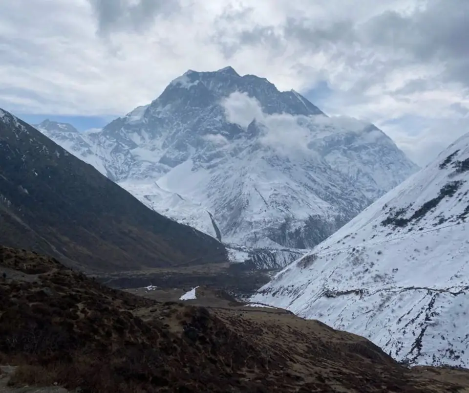 Manaslu's peak rising above a deep glacial valley