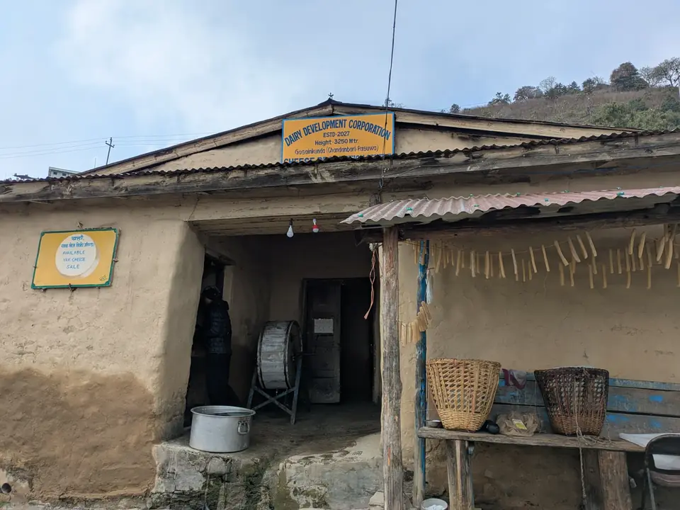 A traditional stone teahouse with drying racks along the trail