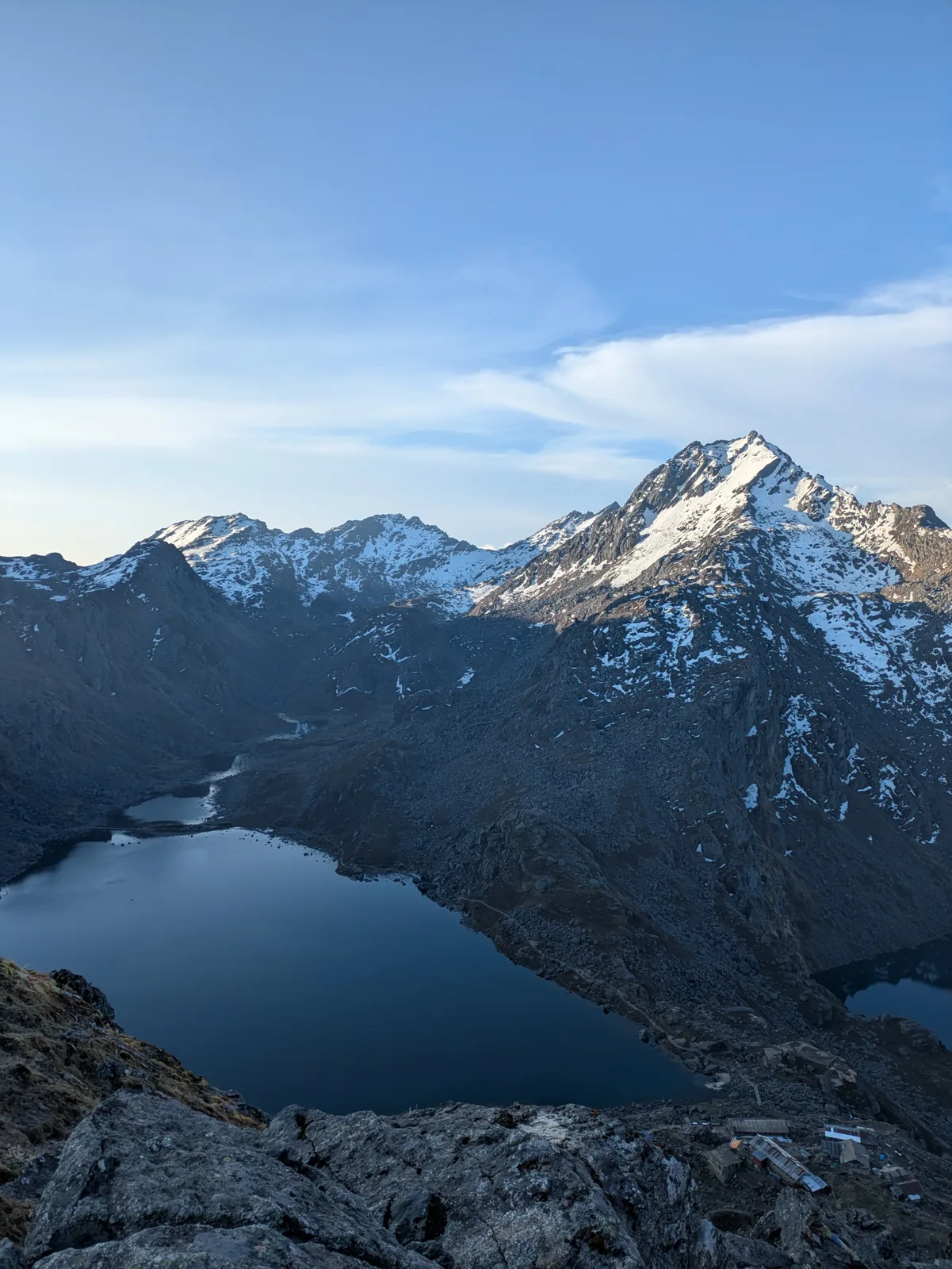 A dark peak rising above a still alpine lake near Gosaikunda
