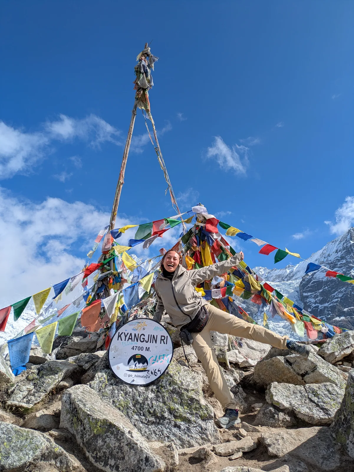 Prayer flags on the Kyanjin Ri summit with snow peaks behind